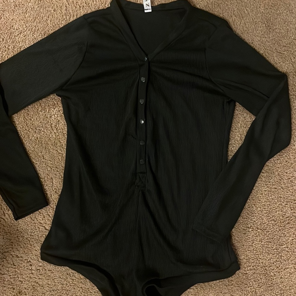 Cute, trendy black long sleeve body suit. S-large but fits like a small .